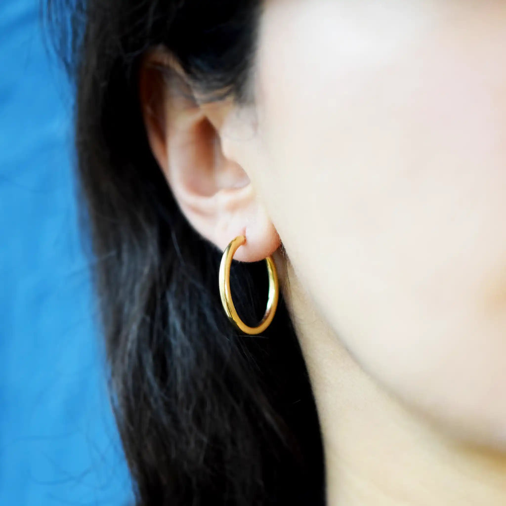 Classic 18 Karat Yellow Gold Hoop Earrings with a smooth, polished finish.