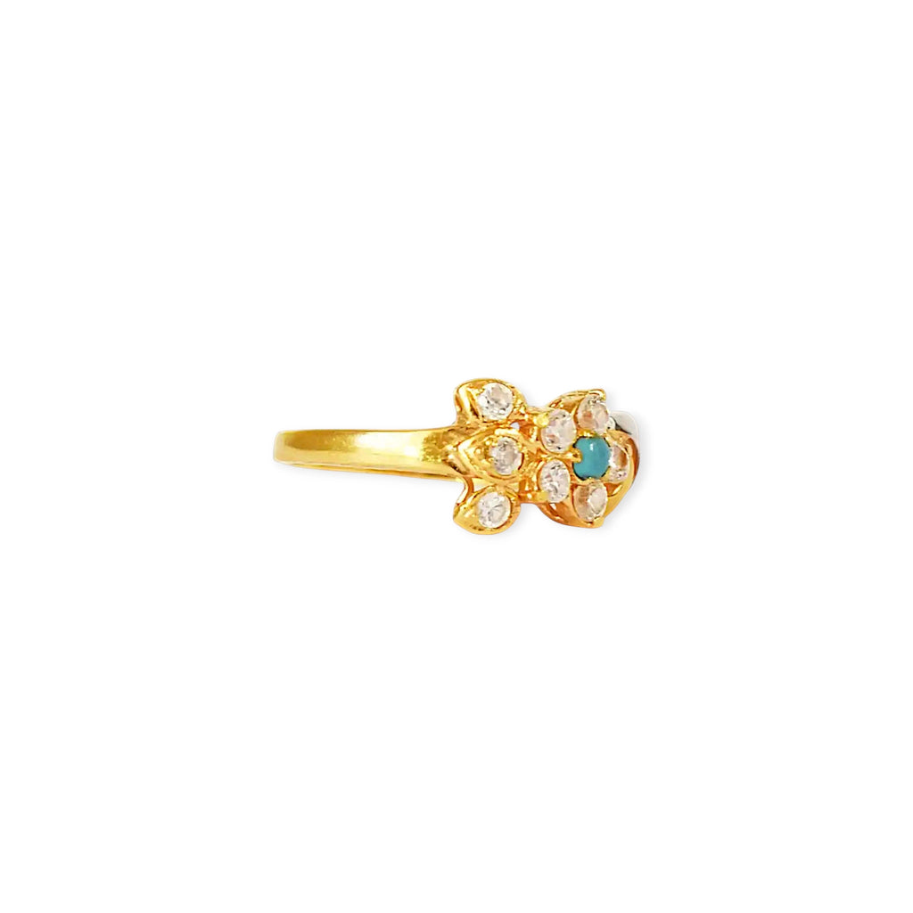 A close-up of a 21k gold ring with a flower-shaped setting, featuring a small round turquoise stone at the center surrounded by clear, brilliant zirconia stones, on a white background.