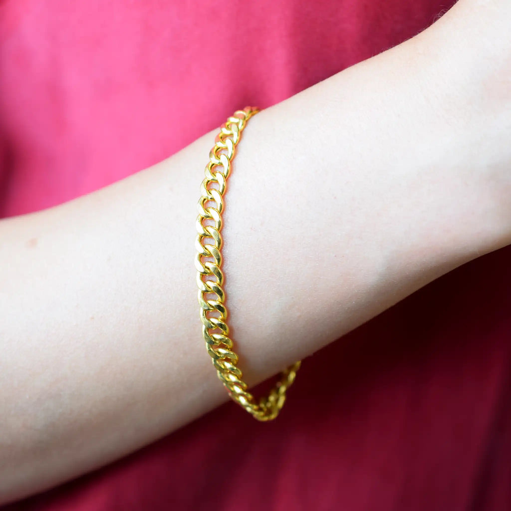 Elegant 21 Karat Yellow Gold flat curb chain bracelet, featuring an ornate clasp with two black-enameled ornamental elements in a classic Greek key pattern.