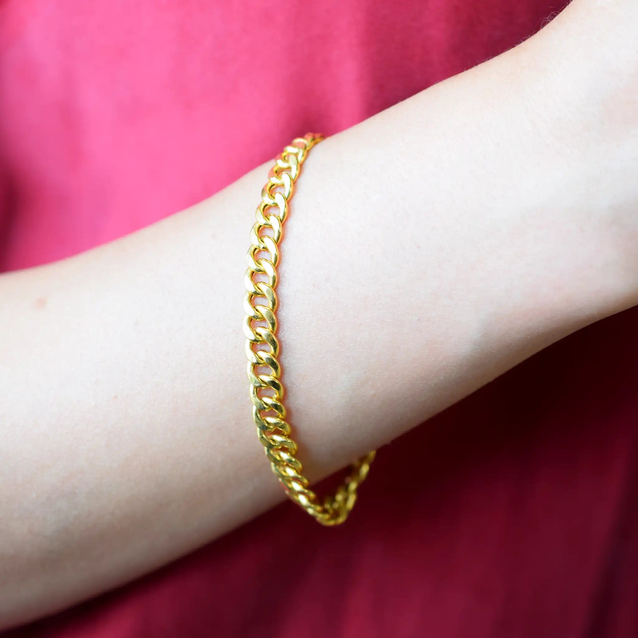 Elegant 21 Karat Yellow Gold flat curb chain bracelet, featuring an ornate clasp with two black-enameled ornamental elements in a classic Greek key pattern.