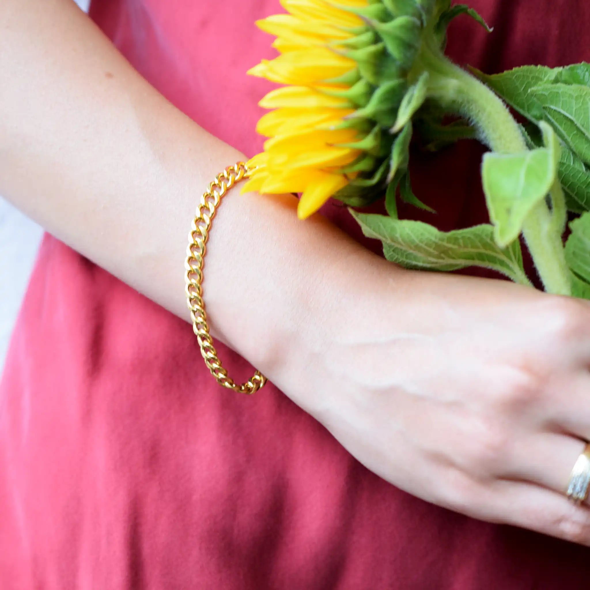 Elegant 21 Karat Yellow Gold flat curb chain bracelet, featuring an ornate clasp with two black-enameled ornamental elements in a classic Greek key pattern.