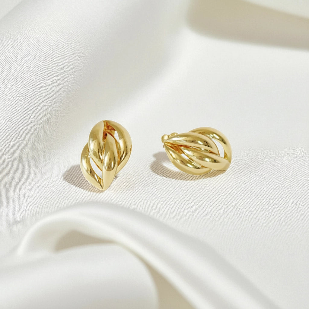 Elegant 14 Karat Yellow Gold post earrings with a highly polished, curved leaf-like design on a white fabric background