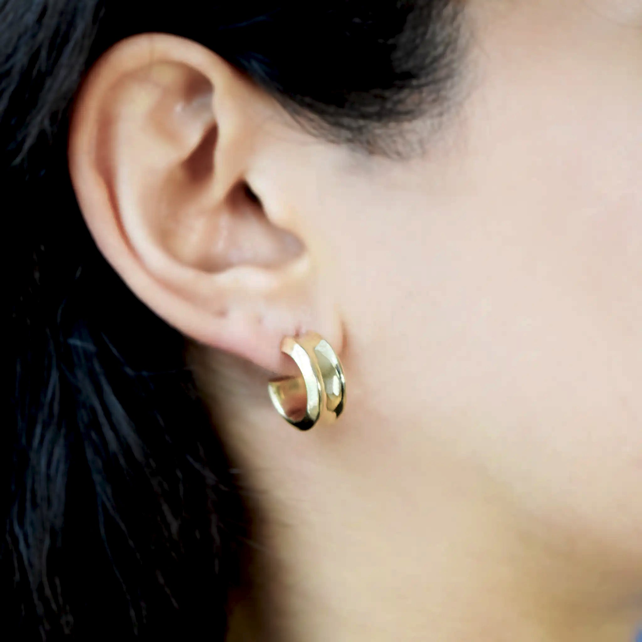 14 Karat Gold hoop earrings on a models ear.