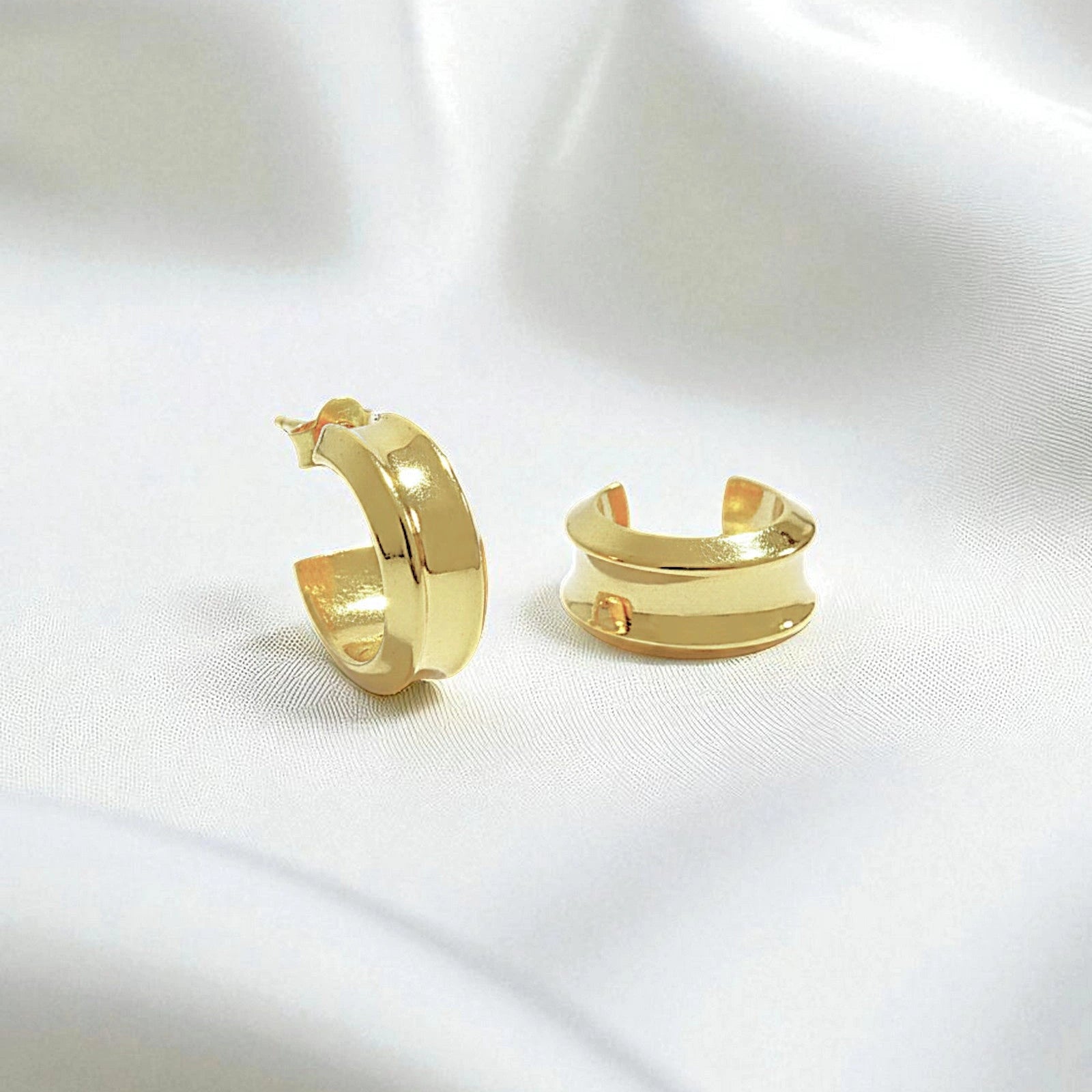 14 Karat Gold hoop earrings on a white silk background.