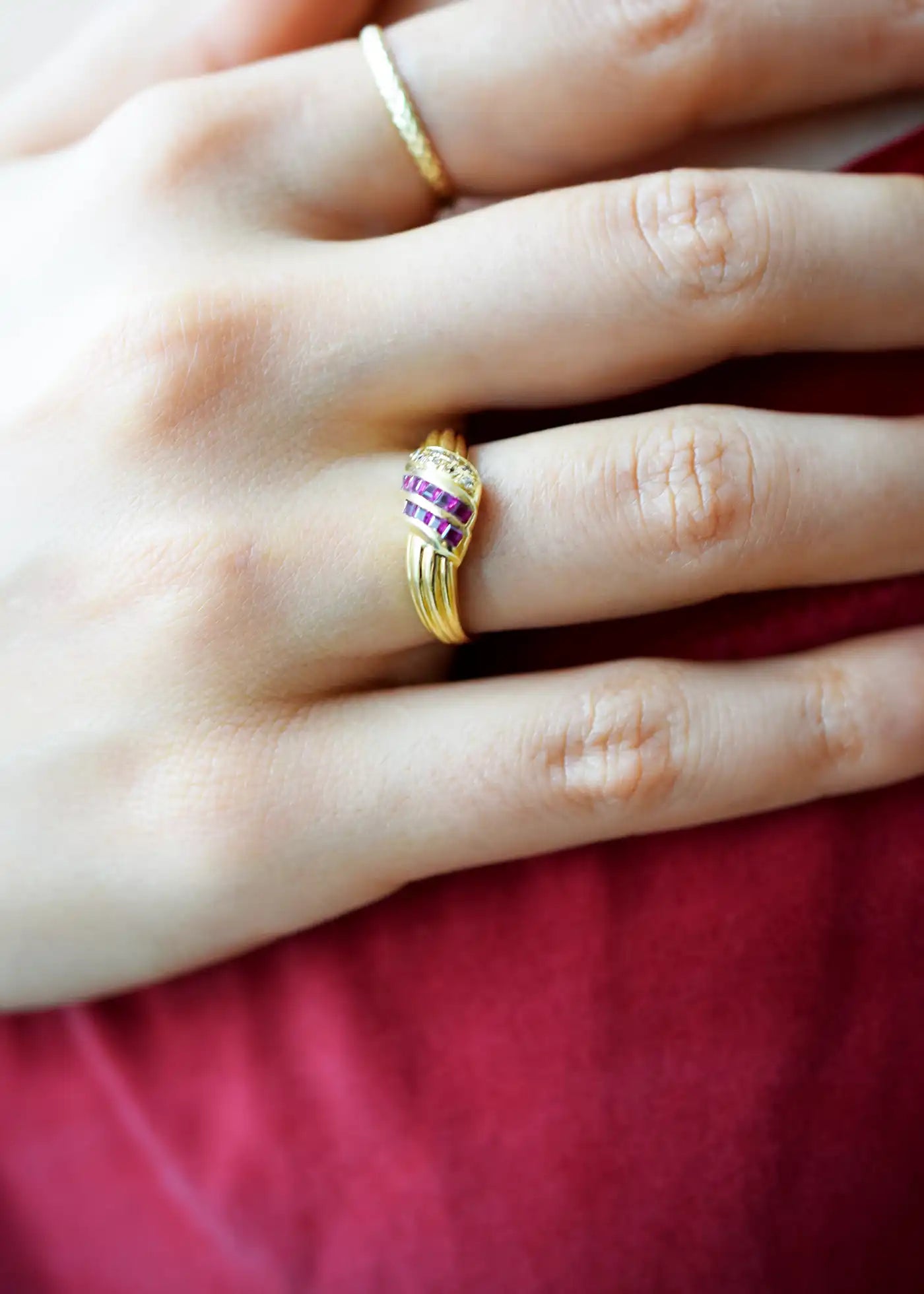 Elegant 18 Karat Yellow Gold Ring in a crossover design with channel-set baguette rubies and pavé-set diamonds.