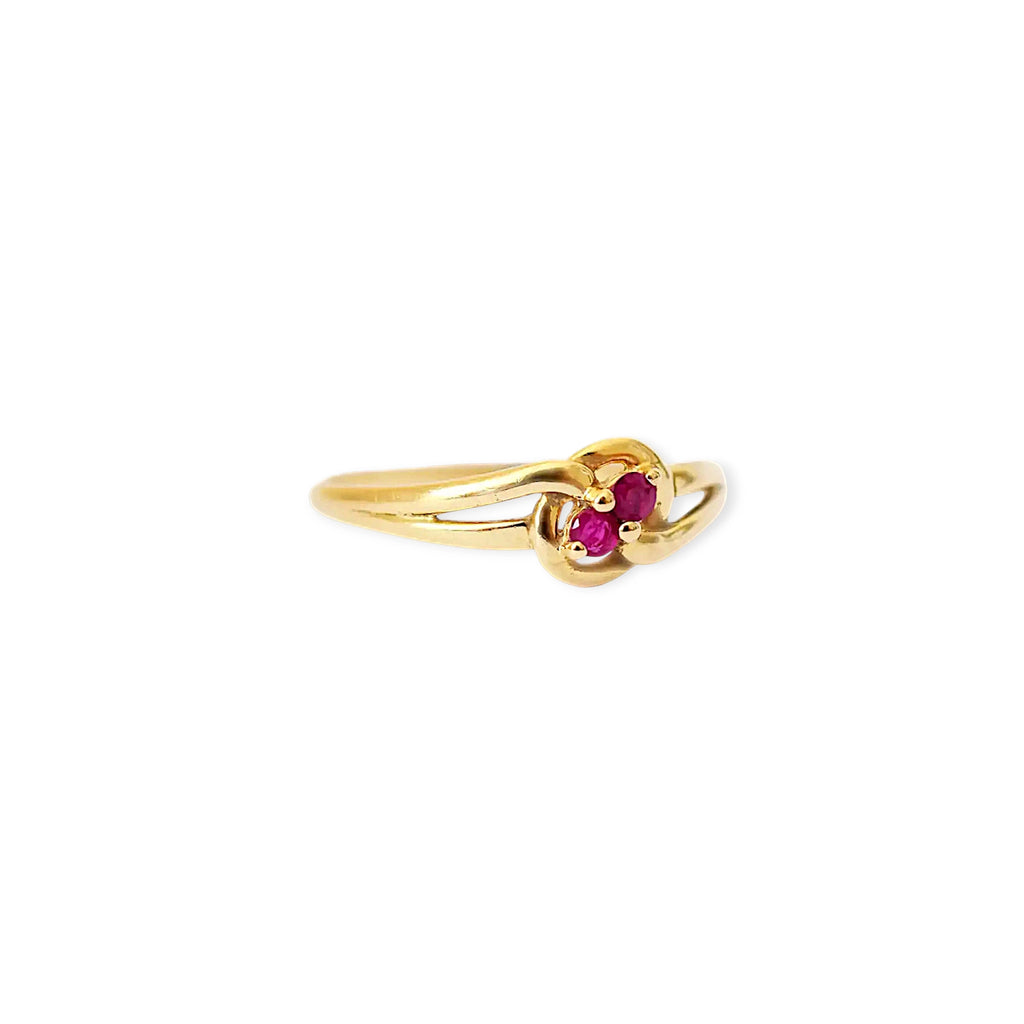 Elegant 18 Karat Yellow Gold vintage ring featuring two vibrant natural rubies nestled in a polished, swirling bypass setting.