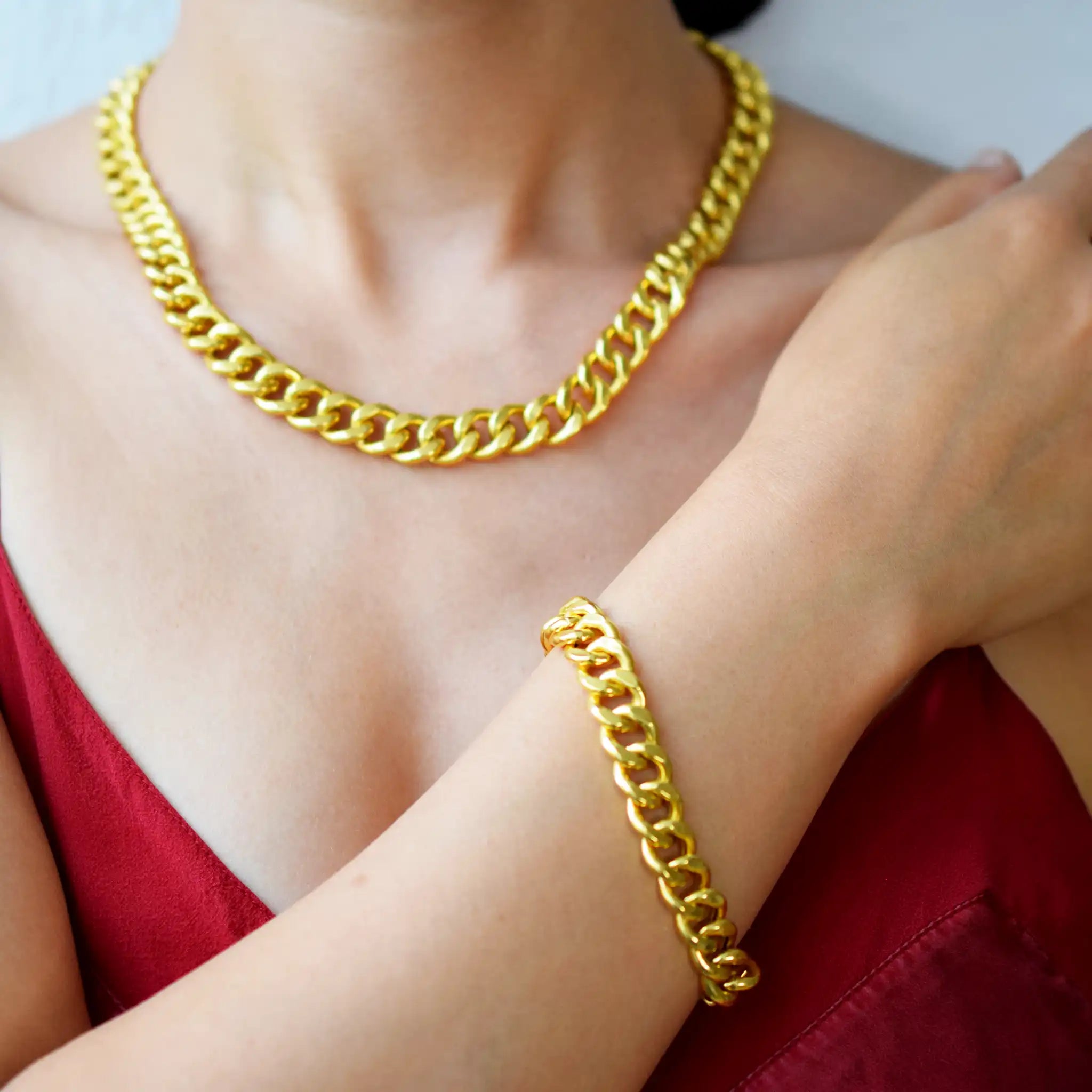 Luxurious 21 Karat Yellow Gold bold flat curb chain bracelet, featuring an ornate clasp with black-enameled ornamental elements in a classic Greek key pattern.