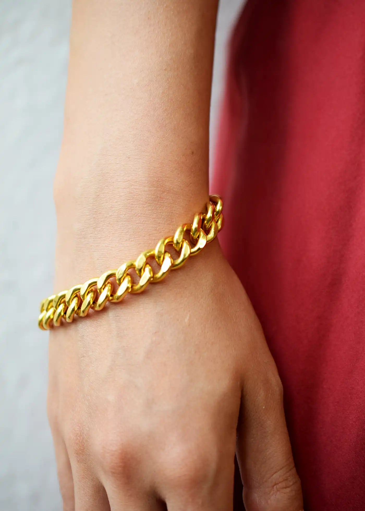 Luxurious 21 Karat Yellow Gold bold flat curb chain bracelet, featuring an ornate clasp with black-enameled ornamental elements in a classic Greek key pattern.