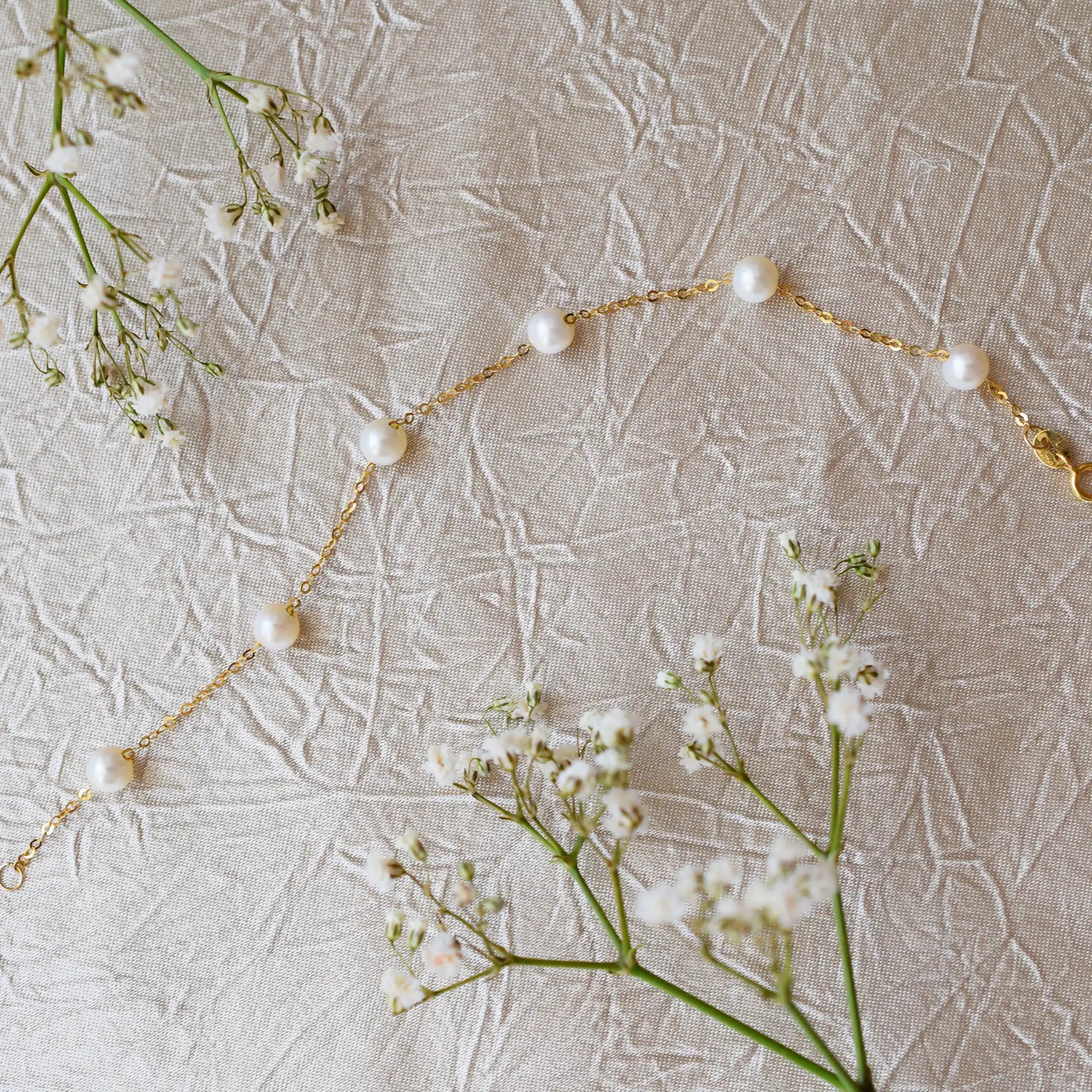 Romantic 18 Karat Yellow Gold bracelet showcasing glowing freshwater pearls along a delicate link chain.