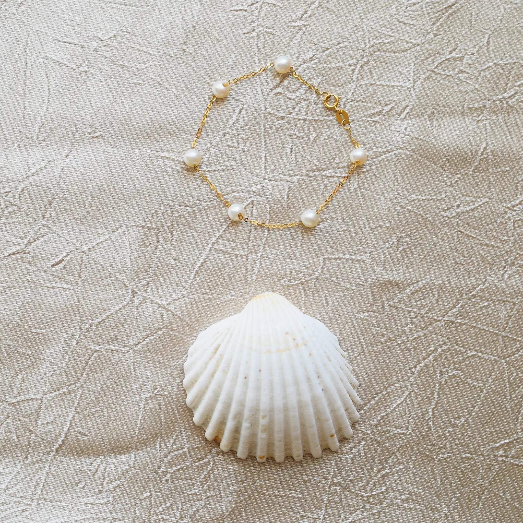 Romantic 18 Karat Yellow Gold bracelet showcasing glowing freshwater pearls along a delicate link chain.