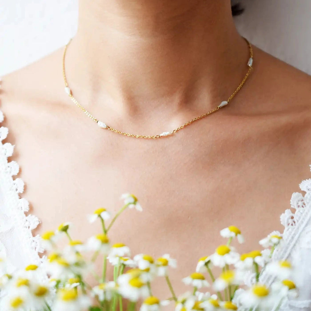 Romantic 18 Karat Yellow Gold necklace featuring irregularly shaped freshwater pearls stationed along a delicate link chain.