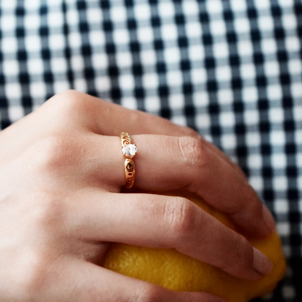 Romantic 21 Karat Yellow Gold ring featuring an oval Cubic Zirconia solitaire, with the words 'Love You' intricately cut out from the wide gold band.