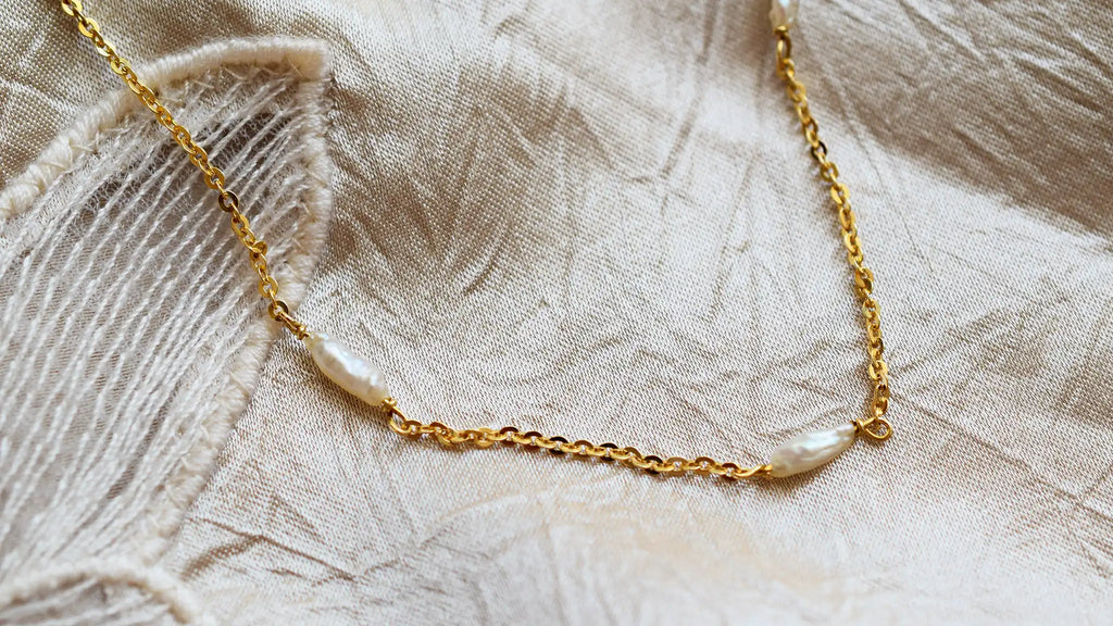 Romantic 18 Karat Yellow Gold necklace featuring irregularly shaped freshwater pearls stationed along a delicate link chain.
