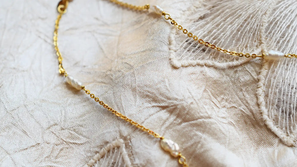 Romantic 18 Karat Yellow Gold necklace featuring irregularly shaped freshwater pearls stationed along a delicate link chain.
